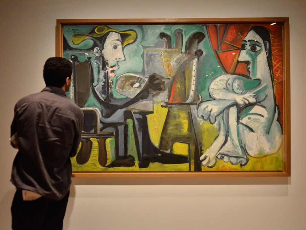 Homem observa a obra "O Pintor e a Modelo" (1963), de Pablo Picasso